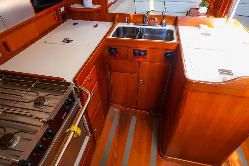 Mojo Yacht Photos Pics 2004 J Boats J/46 yacht kitchen with wooden cabinetry, stove, and double sink.