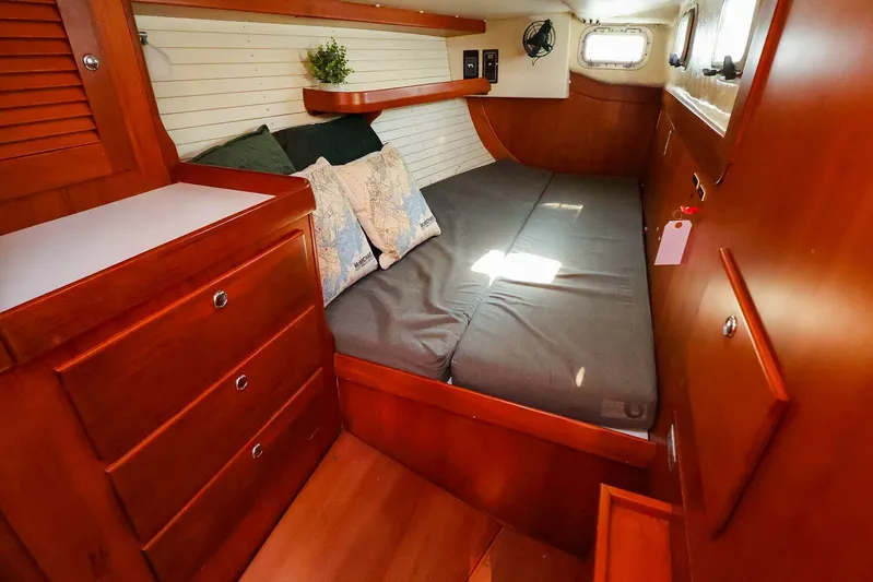 Mojo Yacht Photos Pics 2004 J Boats J/46 cabin interior with wooden furnishings and cozy bedding.
