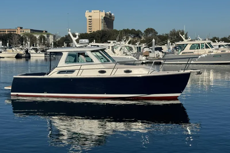 Indigo Yacht Photos Pics 2005 Back Cove 29 boat docked in a marina, reflecting on calm water.