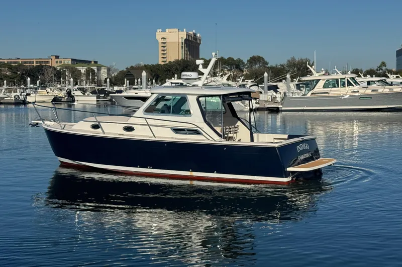 Indigo Yacht Photos Pics 2005 Back Cove 29 boat on calm water, marina background.