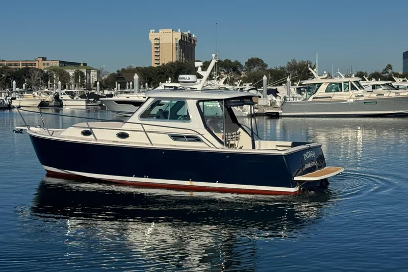 Indigo Yacht Photos Pics 2005 Back Cove 29 boat on calm water near a marina.