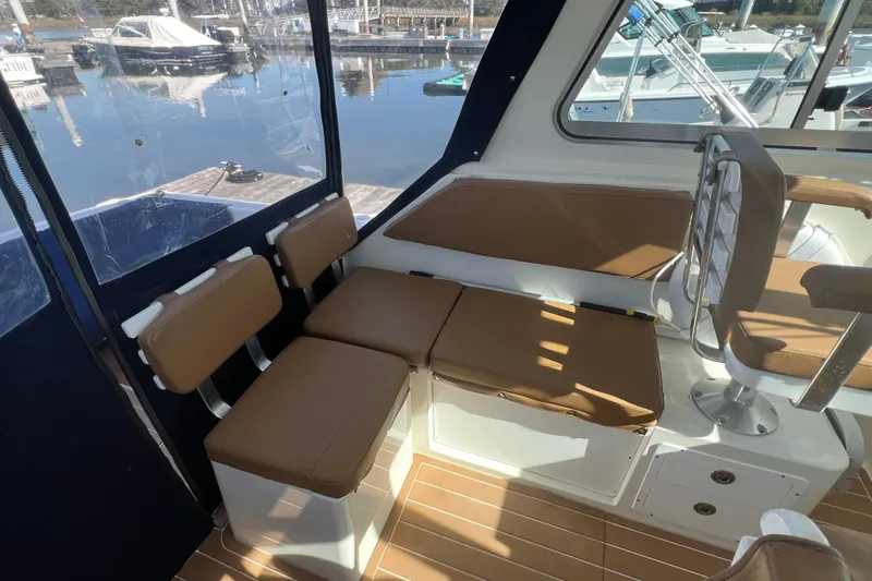 Indigo Yacht Photos Pics 2005 Back Cove 29 boat interior with brown seating and marina view.