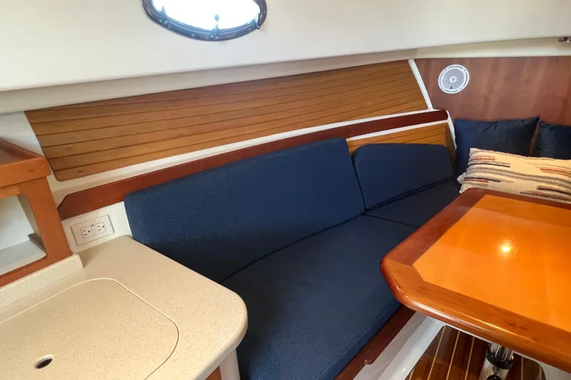 Indigo Yacht Photos Pics 2005 Back Cove 29 interior with blue seating, wooden table, and nautical decor.