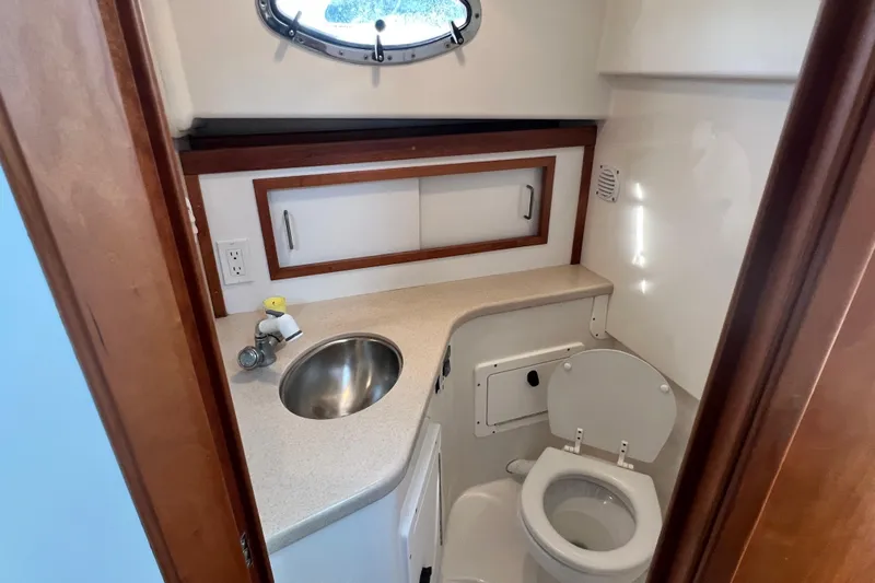 Indigo Yacht Photos Pics 2005 Back Cove 29 boat bathroom with sink, toilet, and storage cabinet.