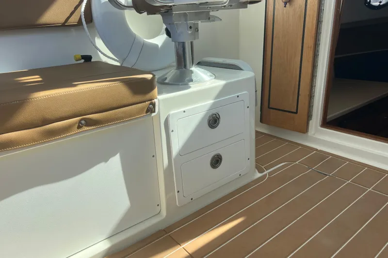 Indigo Yacht Photos Pics 2005 Back Cove 29 interior with cushioned seating and storage drawers.
