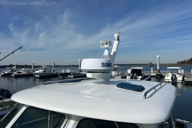 Indigo Yacht Photos Pics 2005 Back Cove 29 boat with radar, docked at marina under clear sky.