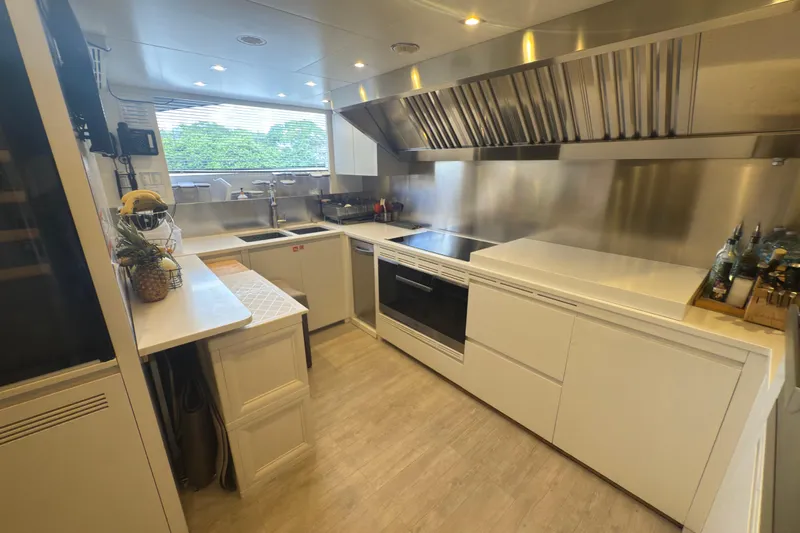 Mr. D Yacht Photos Pics Modern kitchen interior on 2015 Benetti 140 yacht, featuring sleek white cabinetry and stainless steel appliances.