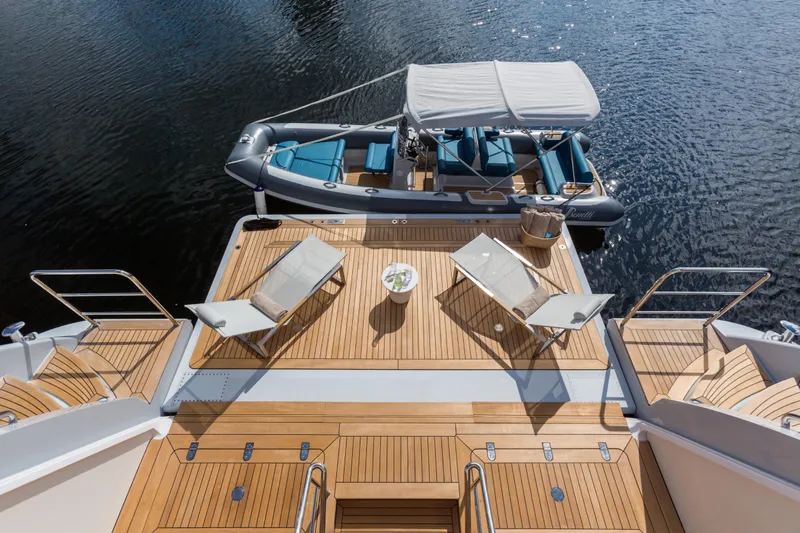 Mr. D Yacht Photos Pics Luxurious 2015 Benetti 140 yacht deck with sun loungers and tender boat on calm water.