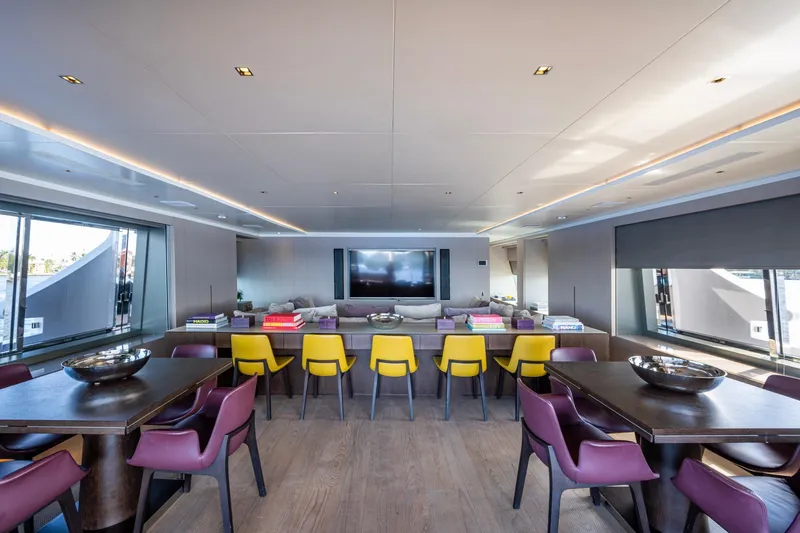 Mr. D Yacht Photos Pics Luxurious interior of 2015 Benetti 140 yacht with modern dining area and vibrant seating.