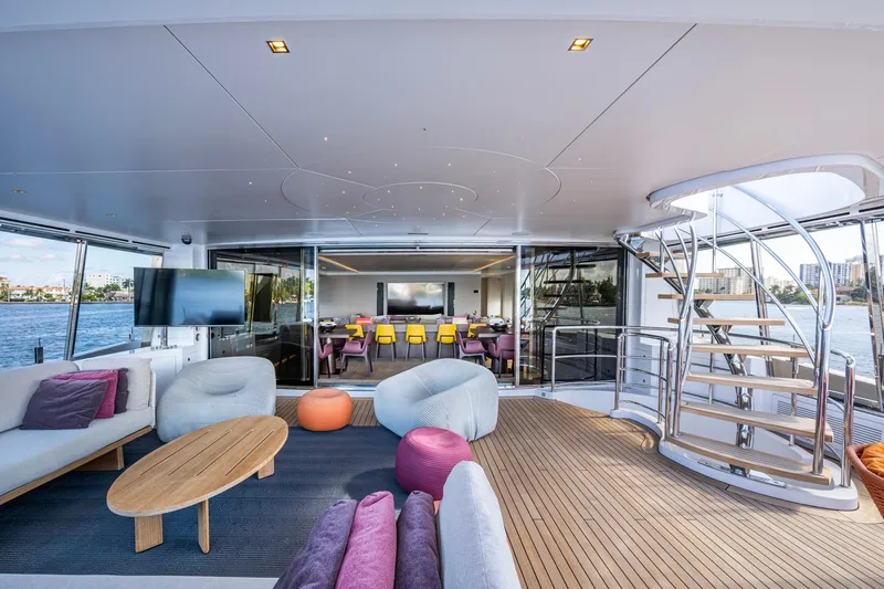 Mr. D Yacht Photos Pics Luxurious 2015 Benetti 140 yacht interior with modern seating, spiral staircase, and waterfront view.