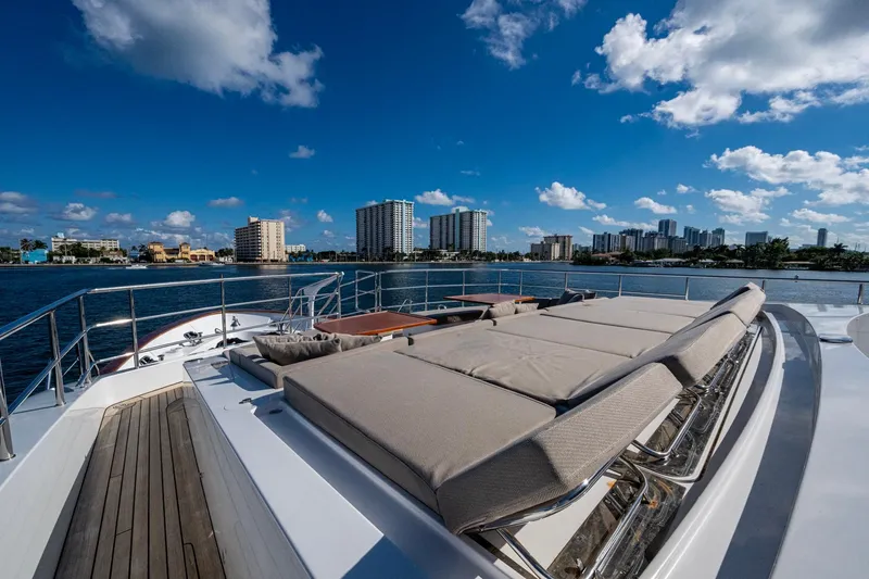 Mr. D Yacht Photos Pics Luxurious 2015 Benetti 140 yacht deck with sun loungers, city skyline in background.