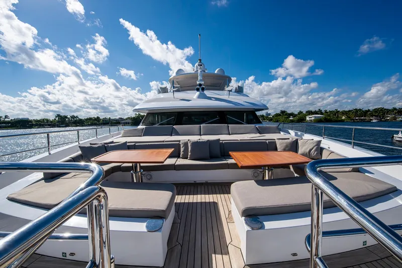 Mr. D Yacht Photos Pics Luxurious 2015 Benetti 140 yacht deck with plush seating and tables, under a clear blue sky.
