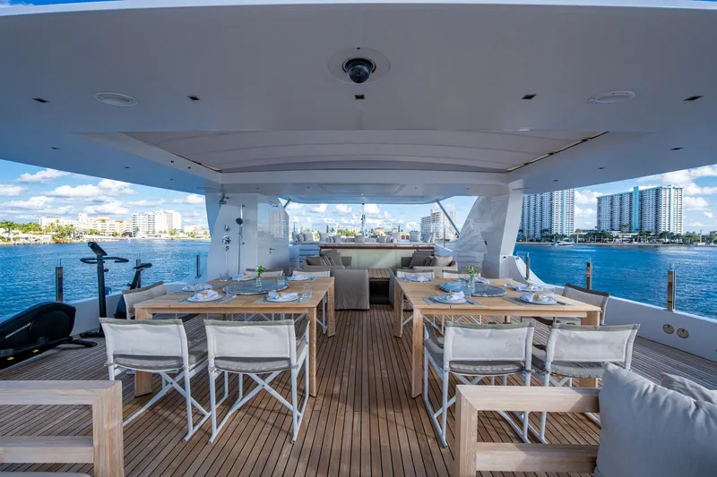 Mr. D Yacht Photos Pics Luxurious 2015 Benetti 140 yacht deck with elegant dining setup and scenic waterfront view.