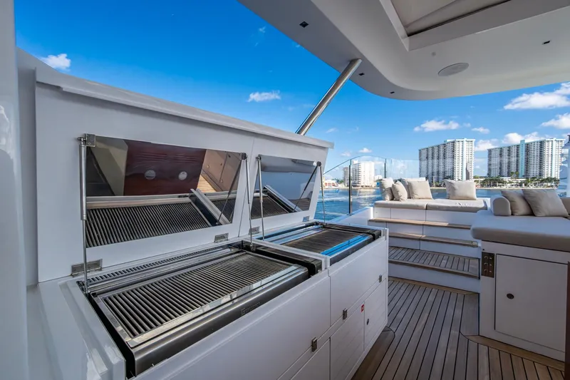 Mr. D Yacht Photos Pics Luxurious 2015 Benetti 140 yacht deck with grill and seating, overlooking waterfront skyline.