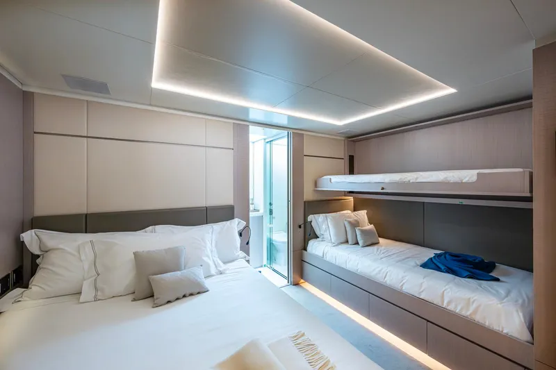 Mr. D Yacht Photos Pics Luxurious bedroom in a 2015 Benetti 140 yacht with modern lighting and cozy bedding.