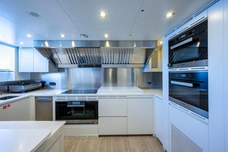 Mr. D Yacht Photos Pics Modern kitchen interior on 2015 Benetti 140 yacht, featuring sleek appliances and stainless steel finishes.