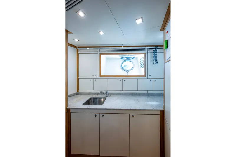 Mr. D Yacht Photos Pics Modern galley kitchen on 2015 Benetti 140 yacht with sleek cabinetry and porthole window.