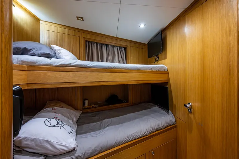 Mr. D Yacht Photos Pics Bunk beds in a 2015 Benetti 140 yacht cabin with wooden interior and TV.