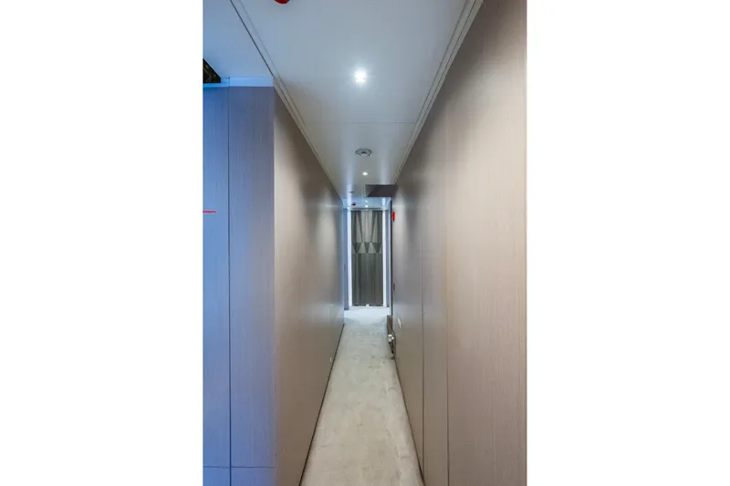 Mr. D Yacht Photos Pics Narrow hallway inside 2015 Benetti 140 yacht, featuring modern wood paneling and soft lighting.