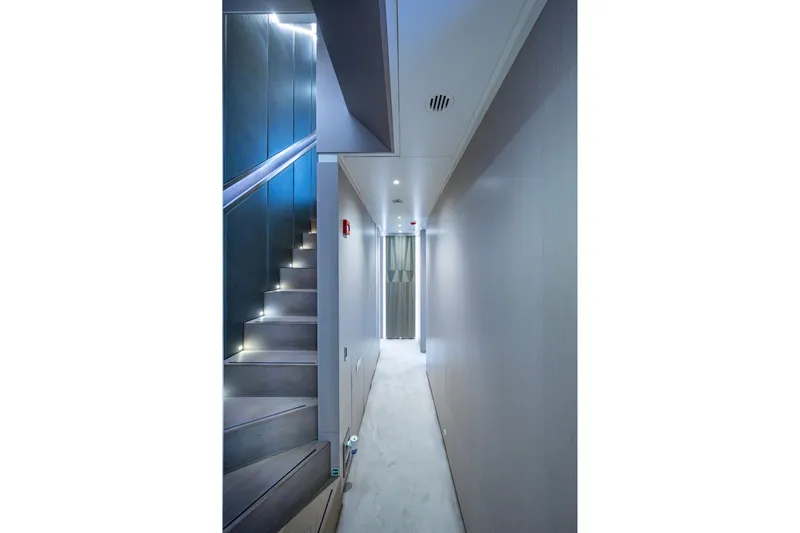 Mr. D Yacht Photos Pics Modern hallway and staircase inside 2015 Benetti 140 yacht, featuring sleek design and ambient lighting.