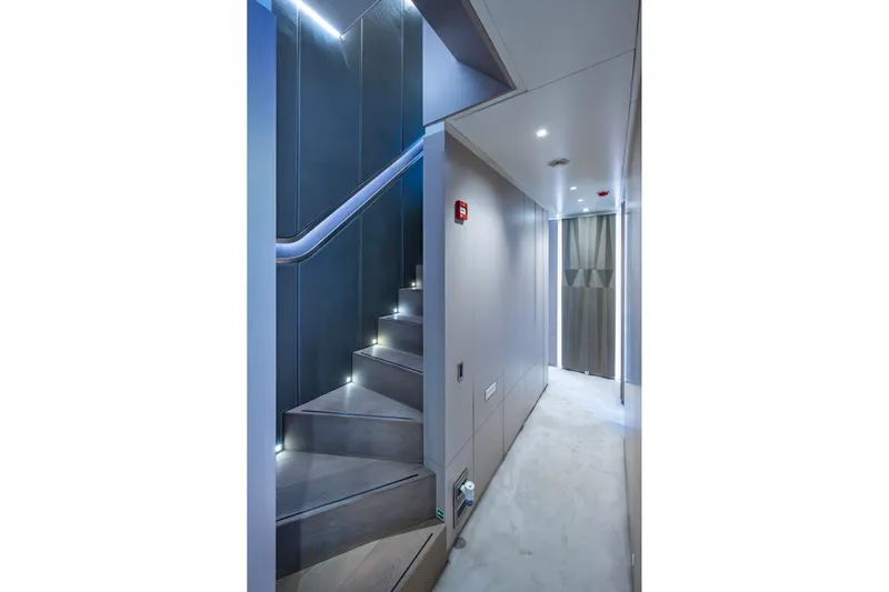Mr. D Yacht Photos Pics Modern interior of 2015 Benetti 140 yacht featuring sleek staircase and illuminated hallway.