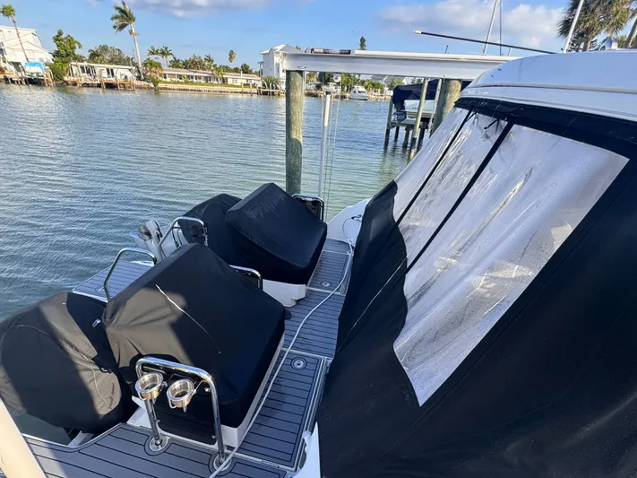  Yacht Photos Pics Aquila 32 Sport 2023 boat docked, featuring covered seating and clear canopy.