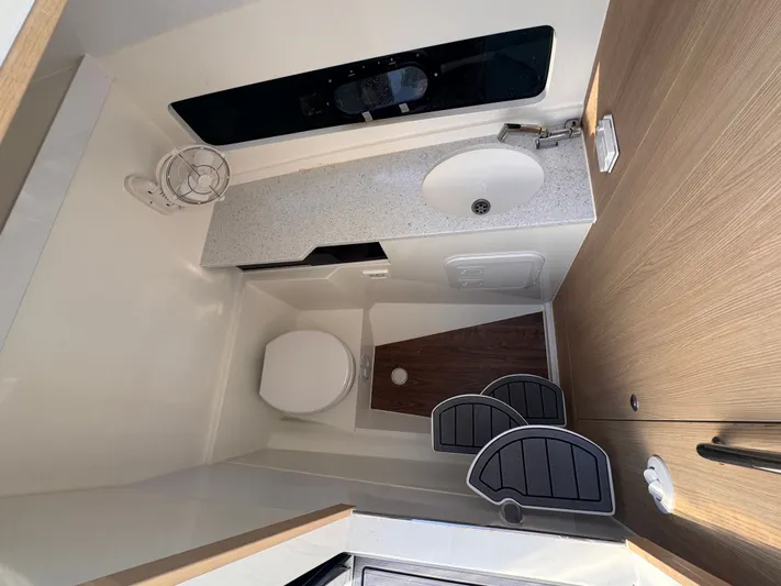  Yacht Photos Pics 2023 Aquila 32 Sport bathroom interior with sink, toilet, and wooden accents.