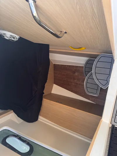  Yacht Photos Pics Interior cabin of 2023 Aquila 32 Sport boat with wooden finish and black bedding.
