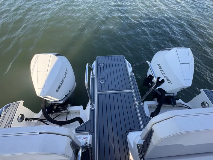  Yacht Photos Pics 2023 Aquila 32 Sport boat with dual Mercury outboard engines on water.