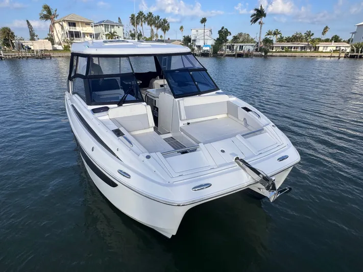  Yacht Photos Pics 2023 Aquila 32 Sport boat on calm water, featuring sleek design and spacious deck.