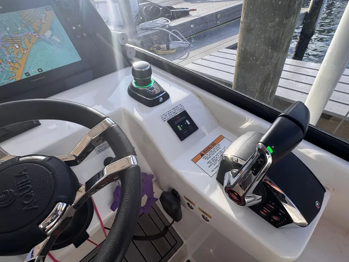  Yacht Photos Pics Control panel of 2023 Aquila 32 Sport boat with steering wheel and navigation system.