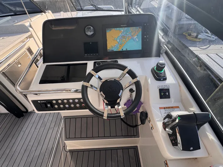  Yacht Photos Pics 2023 Aquila 32 Sport helm with navigation display and controls.