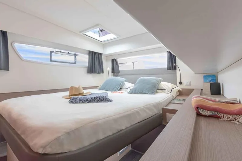  Yacht Photos Pics Luxurious cabin interior of 2025 Fountaine Pajot Elba 45 catamaran, featuring a cozy bed.
