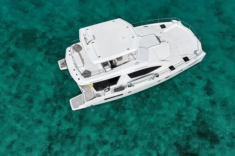 Somewhere Hot Yacht Photos Pics Aerial view of 2014 Leopard 51 Powercat yacht on clear turquoise water.