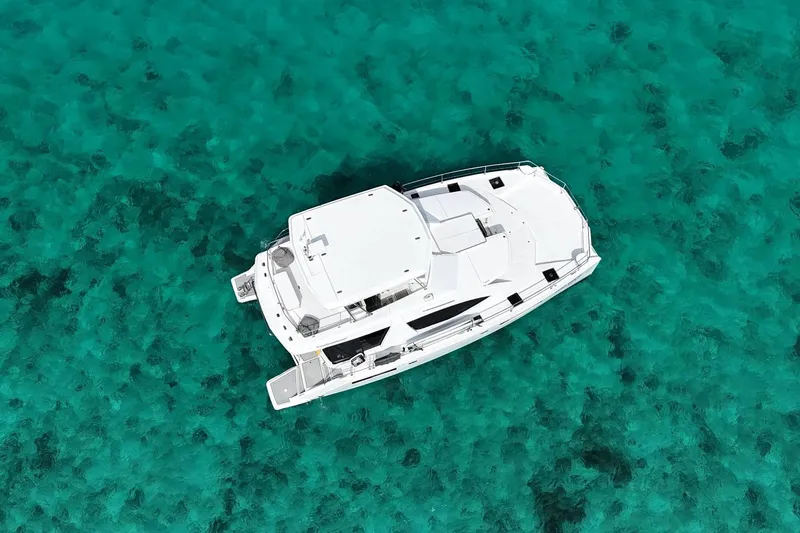 Somewhere Hot Yacht Photos Pics Aerial view of 2014 Leopard 51 Powercat on clear turquoise water.