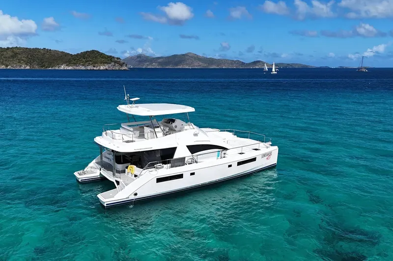 Somewhere Hot Yacht Photos Pics 2014 Leopard 51 Powercat yacht on clear turquoise water, scenic island backdrop.