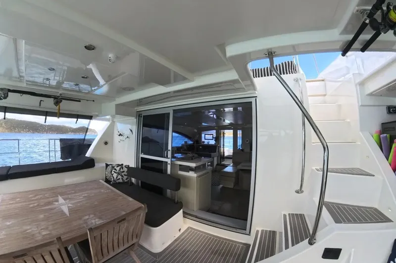 Somewhere Hot Yacht Photos Pics 2014 Leopard 51 Powercat yacht interior with dining area and staircase, overlooking the ocean.
