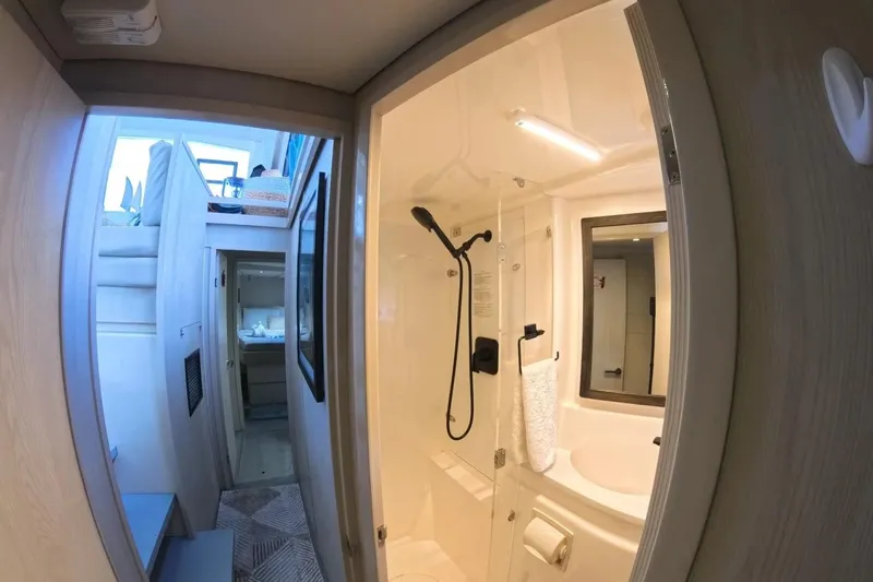 Somewhere Hot Yacht Photos Pics Interior of 2014 Leopard 51 Powercat, featuring a modern bathroom and cozy living space.