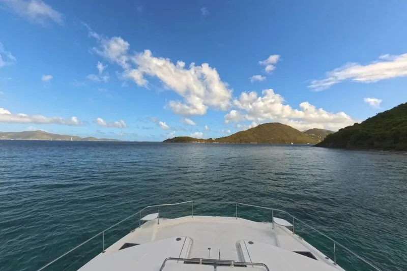 Somewhere Hot Yacht Photos Pics Bow view from 2014 Leopard 51 Powercat, overlooking serene ocean and distant islands under blue sky.