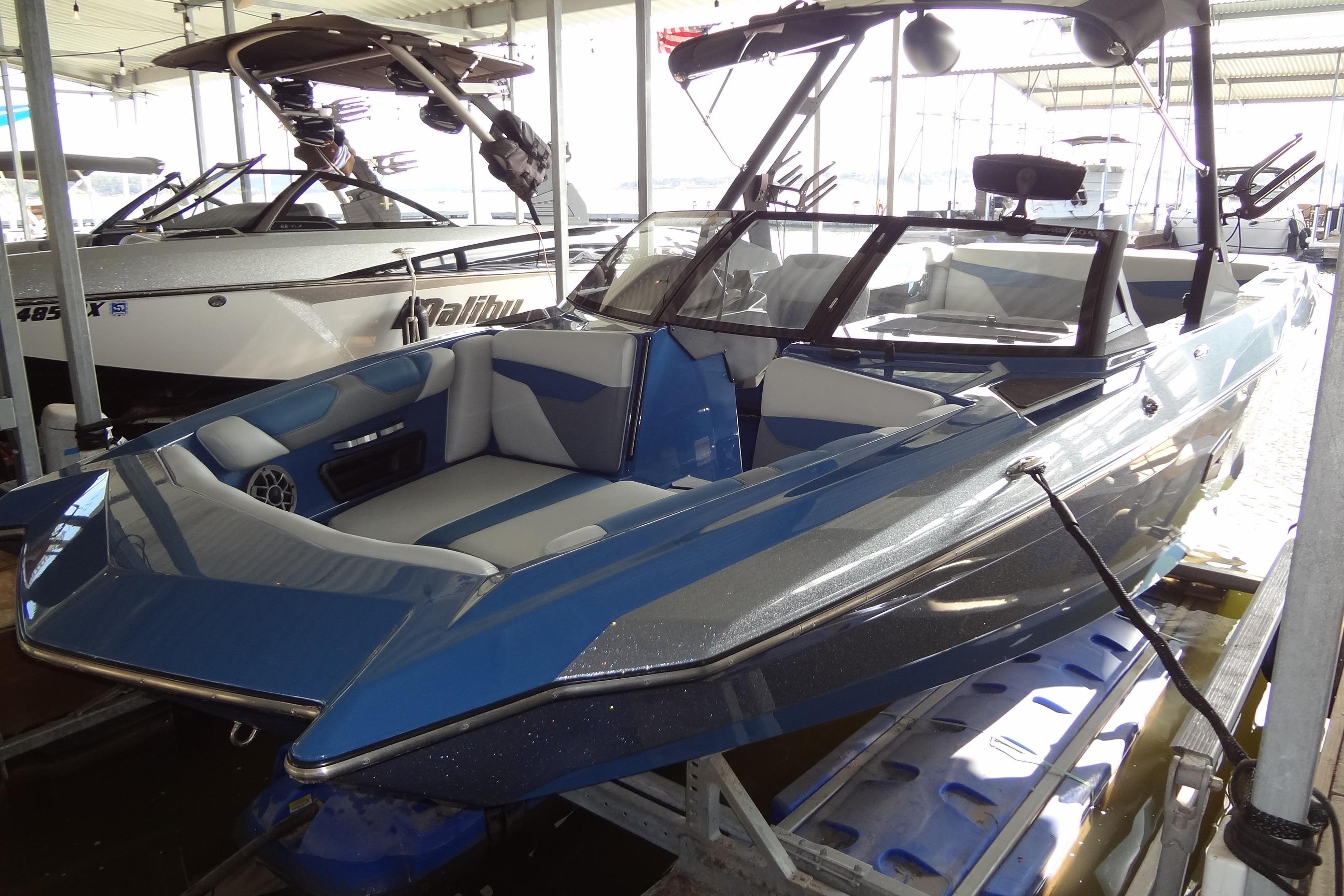 2021 Axis A24 boat in a marina, featuring sleek blue and gray design.