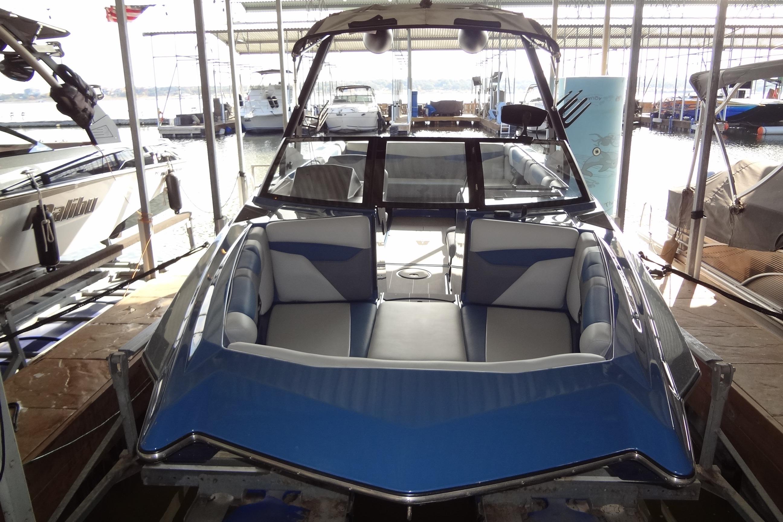 2021 Axis A24 boat with blue and gray interior, docked in a marina.