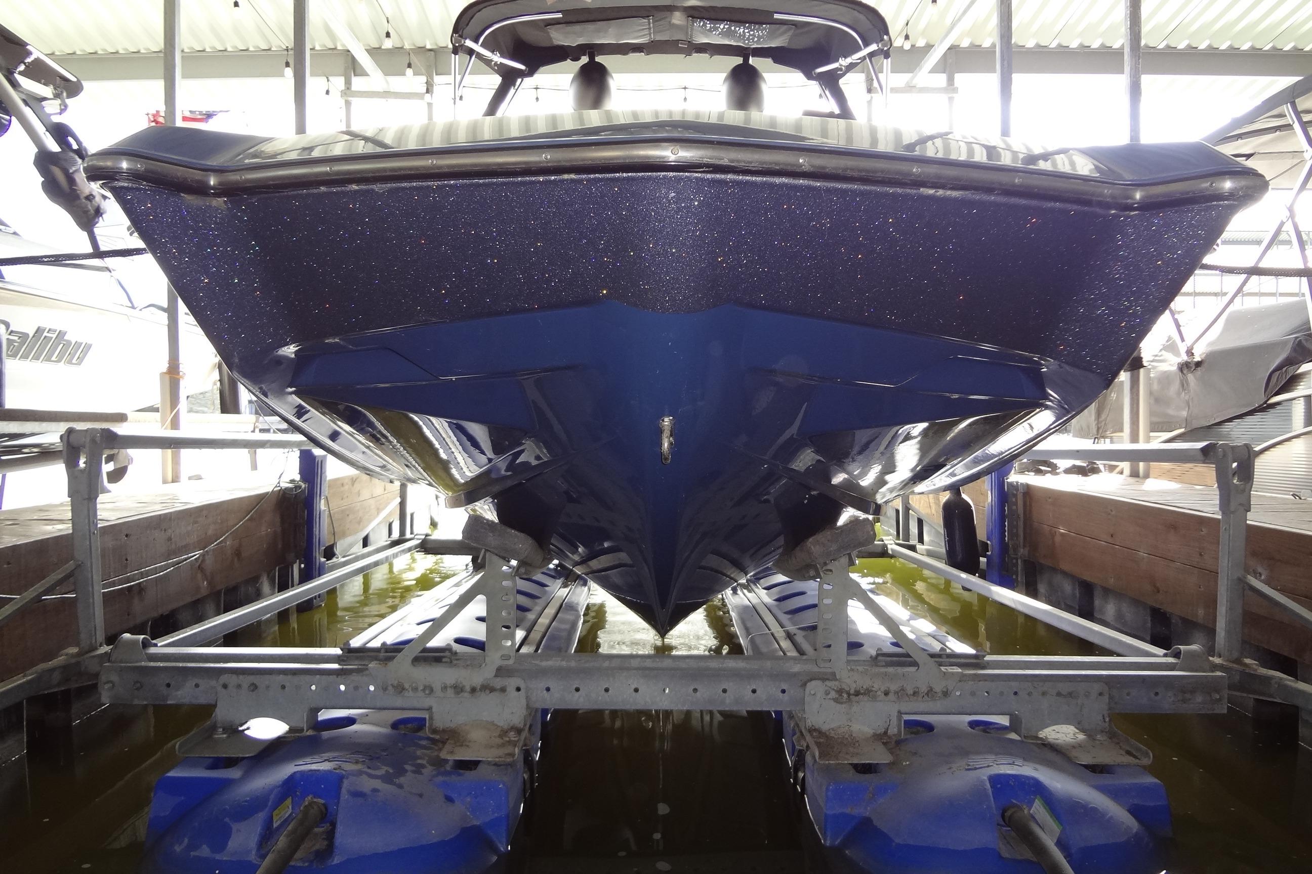 2021 Axis A24 boat in dry dock, showcasing sleek blue hull design.