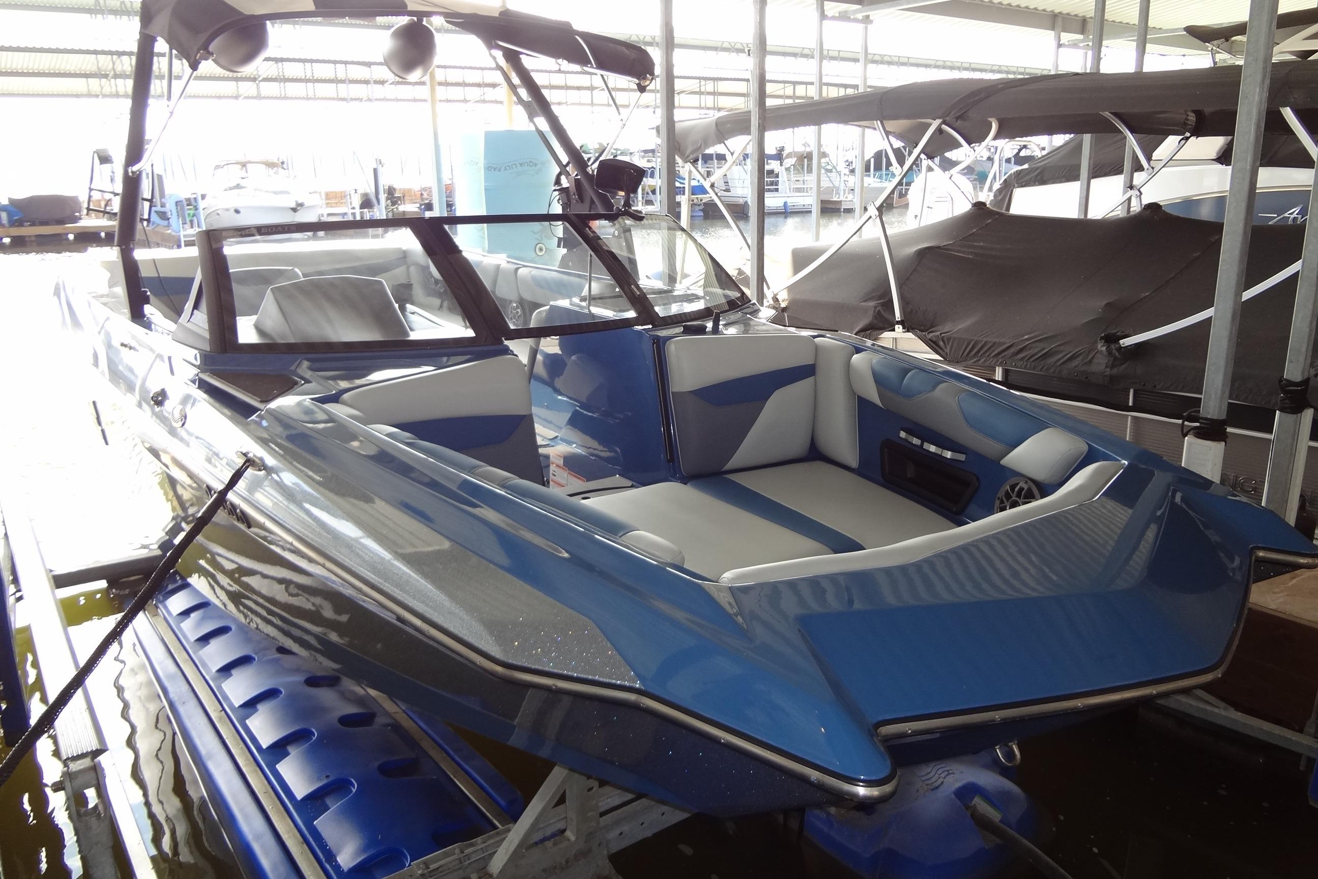 2021 Axis A24 boat in dock, featuring sleek blue and white design.