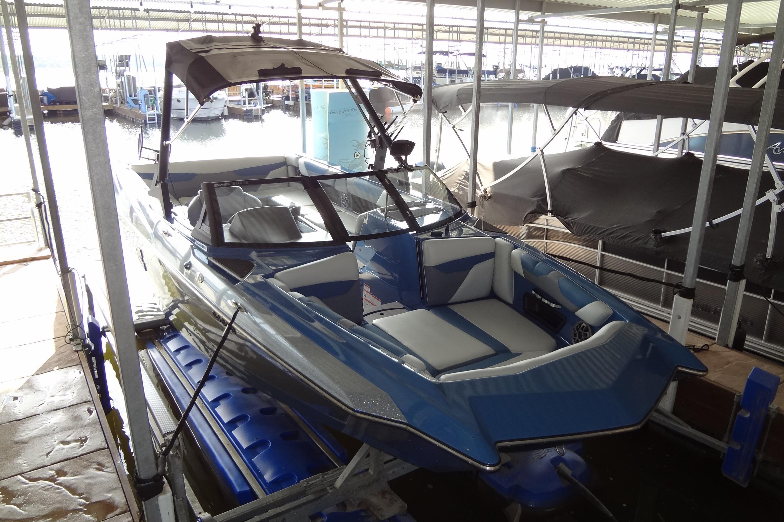 2021 Axis A24 boat in dock, featuring sleek blue and white design.