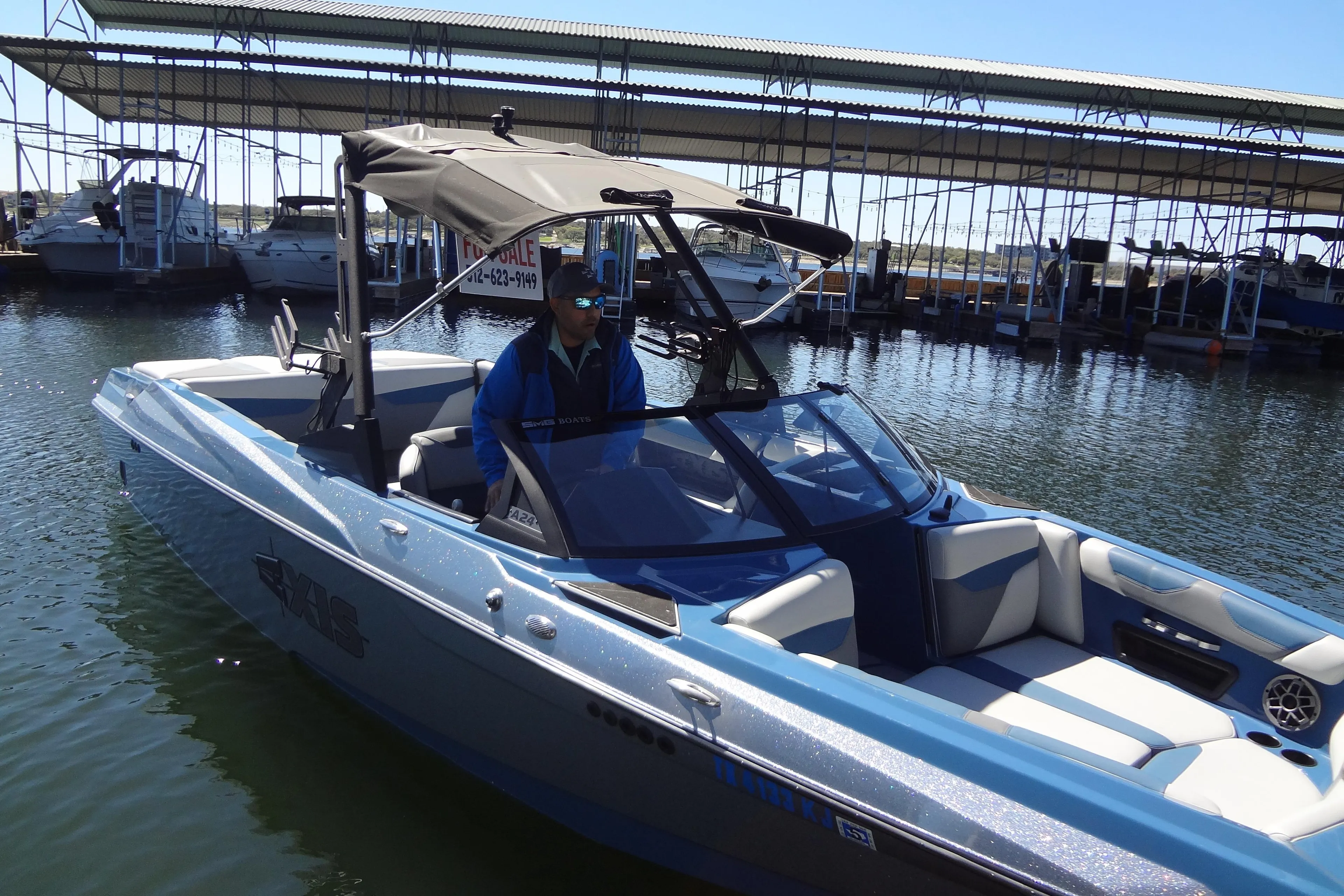 2021 Axis A24 boat docked at marina with canopy and seating.