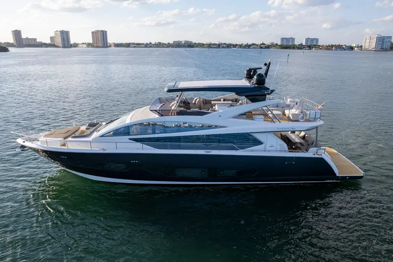  Yacht Photos Pics Luxurious 2020 Pearl 80 yacht cruising on calm waters with city skyline backdrop.