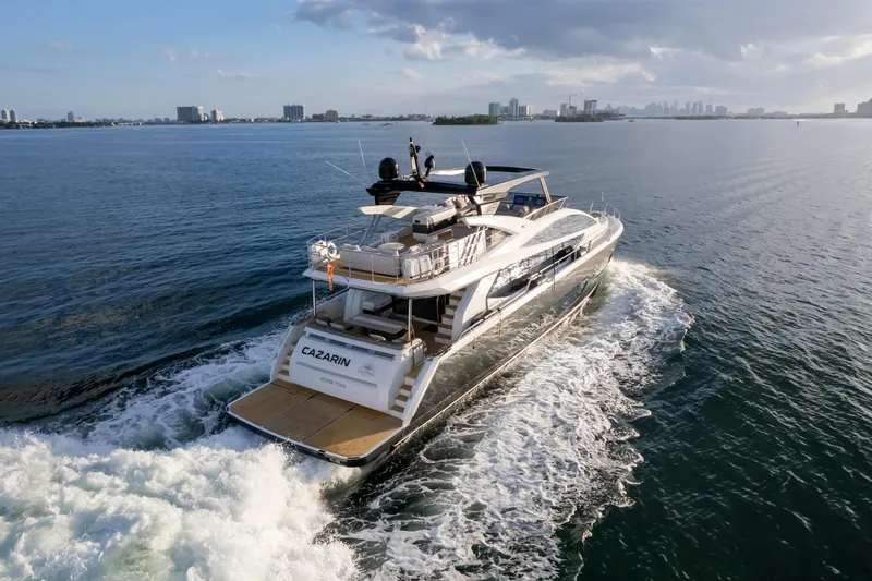  Yacht Photos Pics Luxury Pearl 80 yacht cruising on open water, 2020 model, city skyline in background.
