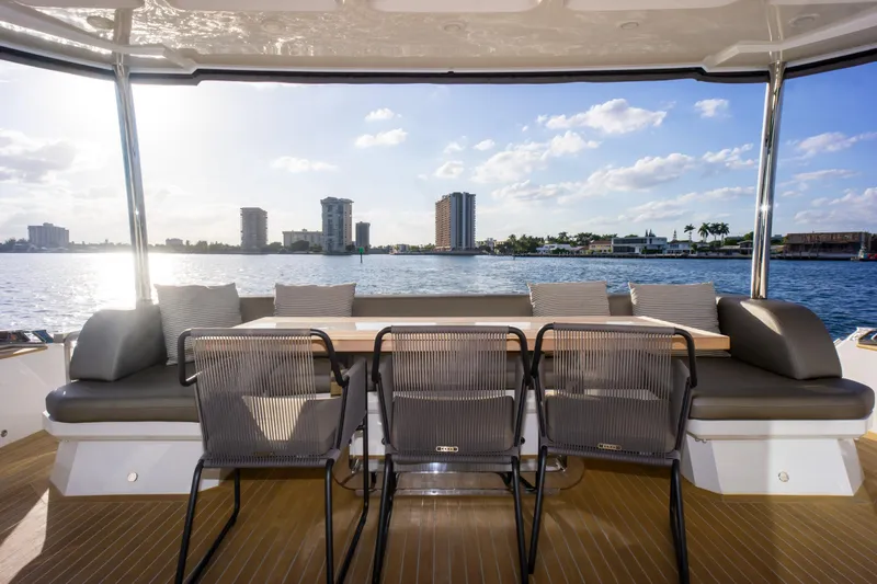  Yacht Photos Pics Luxury yacht Pearl 80, 2020 model, with elegant outdoor seating and scenic waterfront view.