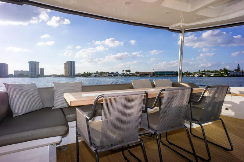  Yacht Photos Pics Luxurious Pearl 80 yacht deck with seating, overlooking a scenic waterfront view.