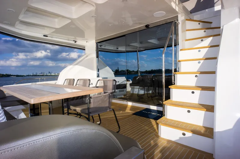  Yacht Photos Pics Luxurious Pearl 80 yacht interior, featuring elegant seating, wooden stairs, and scenic ocean views.